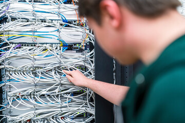 Close-up of teenager working with cables in server room