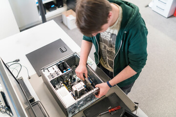 Teenager assembling personal computer - Powered by Adobe