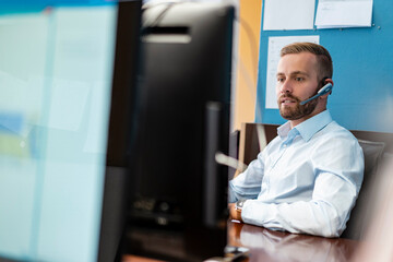 Businessman with headset at desk in office