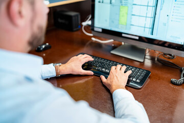 Fototapeta na wymiar Close-up of businessman working on desktop pc in office