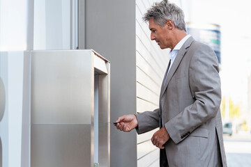 Mature businessman withdrawing money at an ATM