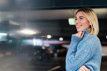 Portrait of a smiling young woman in a parking garage