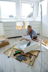 Woman reading assembly instructions at home