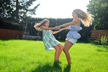 Two happy playful girls in garden