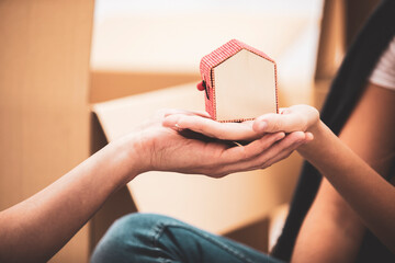 Close-up of couple holding tiny house model