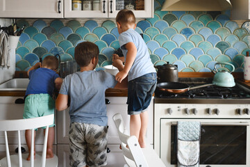 Three brothers cooking pancakes in the kitchen