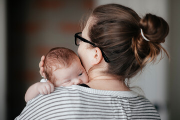 Portrait of a young woman with a baby at home