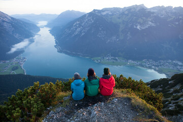 Fototapeta na wymiar Austria, Tyrol, three hikers enjoying the view on Achensee