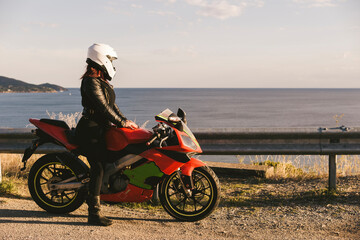 Italy, Elba Island, female motorcyclist at viewpoint