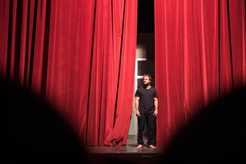 Barefoot actor standing on theatre stage