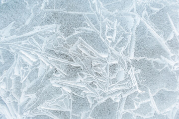 Background frozen water with fancy patterns. Ice texture. Cracks and bubbles inside frozen water.