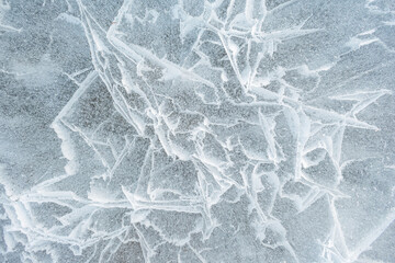 Background frozen water with fancy patterns. Ice texture. Cracks and bubbles inside frozen water.