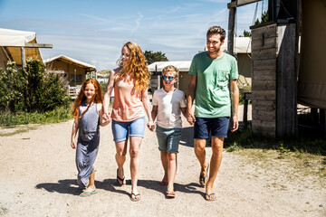 Netherlands, Zandvoort, happy family walking on campsite