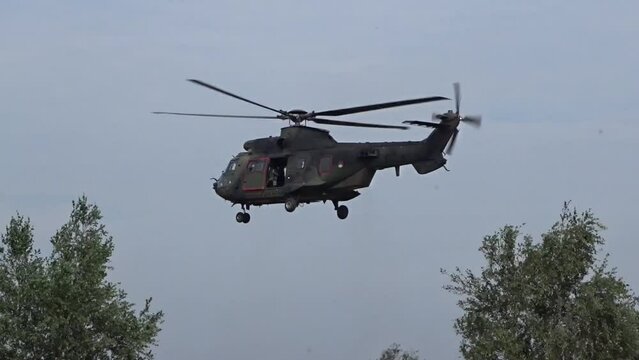 Military helicopter Hovering between trees