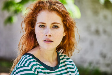 Portrait of redheaded young woman with freckles