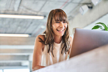 Woman smiling while using laptop at home