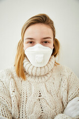 Portrait of blond woman wearing FFP2 mask at home