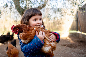 Portrait of smiling toddler girl holding chicken