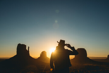 USA, Utah, Monument Valley, silhouette of man with cowboy hat watching sunrise