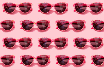 Pattern of pink retro sunglasses against pastel pink background