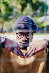 Portrait of a cool young man behind a metal net