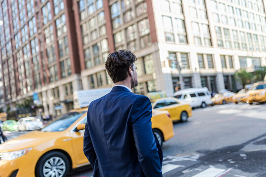 Businessman in the streets of Manhattan with yellow cab in background