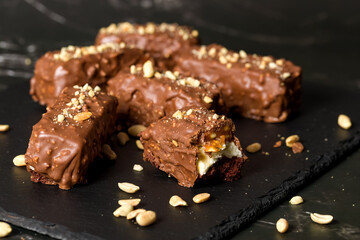 Chocolate sticks with peanuts on a dark background. Home cooking concept
