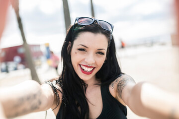Portrait of happy young woman with nose piercing and tattoos