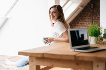 Young woman at home using laptop