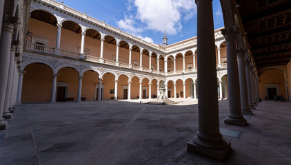 Low angle view of the empty cloister without people of the Alcázar of Toledo, Spain, with blue sky
