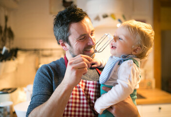 Obraz na płótnie Canvas Father and baby boy in kitchen baking a cake