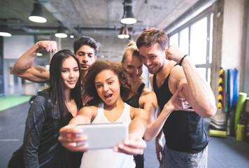 Group of young people posing for a selfie in gym
