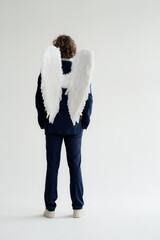 Businessman wearing suit and angel's wings, rear view