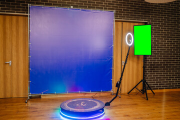 Defocused view of a 360 photo booth used at an event. Banner and TV green screen.