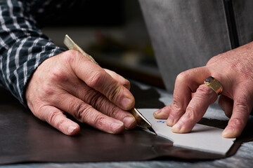 Close-up of shoemaker working on template in his workshop