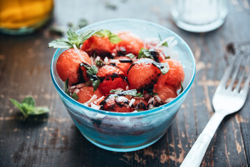 Watermelon salad with eschalot, mint, olive oil and balsamico in bowl