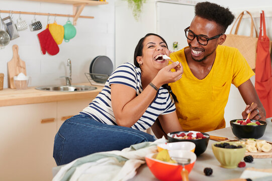 Multiethnic couple breakfasting together in the kitchen