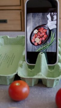 DIY smartphone stand made from egg carton. Vertical pan footage.