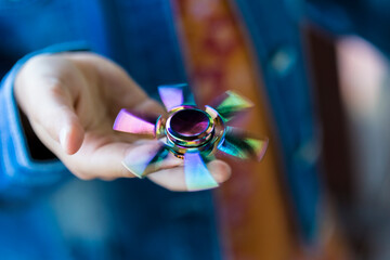 Hand of girl holding rotating Fidget Spinner