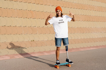 Young disabled man standing on skateboard at sports court