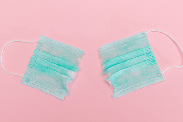 Anti Mask Movement - Green Torn Medical Face Mask on the Pink Background. Pandemic and Lockdown End - Top View, Flat Lay