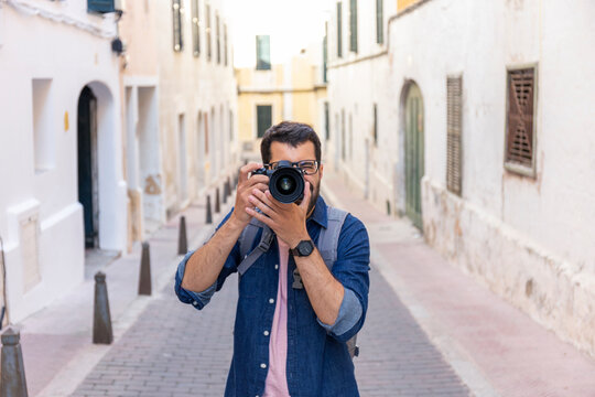 Man taking photos with camera in the city, Mao, Menorca, Spain