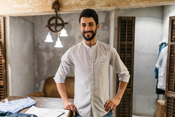 Portrait of smiling man wearing shirt in menswear shop