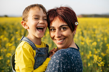Portrait of mother and little son in a rape field