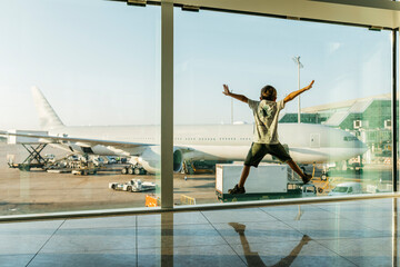 Spain, Barcelona airport, Boy in departure area, jumping in front of glass pane