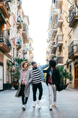 Three happy friends walking in the city