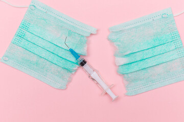 Anti Vaccine Movement and Anti Mask Concept - Broken Medical Syringe and Green Torn Medical Face...