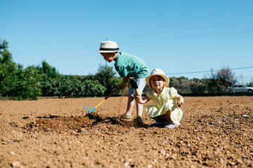 Boy and girl plowing the ground