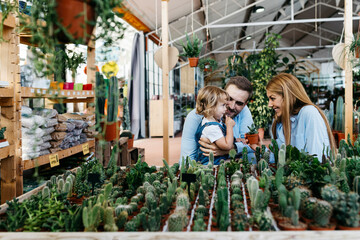 Mother, father and daughter in the cactus area inside a garden center