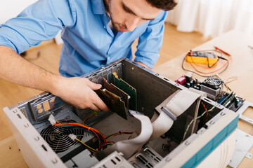 Technician repairing a desktop computer, changing circuit board